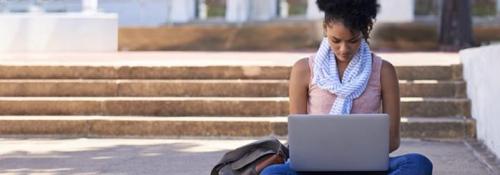 Student studying on steps with laptop
